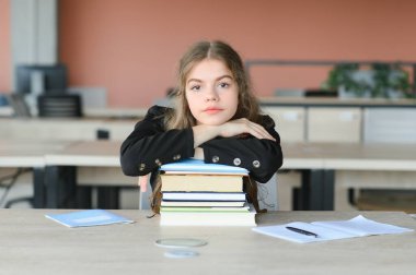 Okuldaki bir kızın portresi. O, kitapları elinde tutuyor. Eğitim kavramı