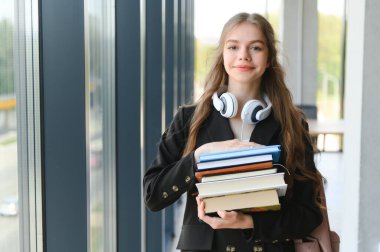 Eğitim ve okul konsepti - Öğrenci kız okulda okuyor ve kitap okuyor
