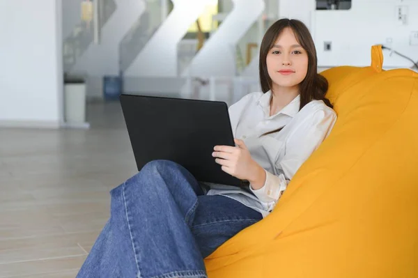 美人の白人女性学生が大学に遠隔で勉強している 彼女はノートパソコンとノートパッドに座っていて ビデオ会議のレッスンを見て集中しています — ストック写真