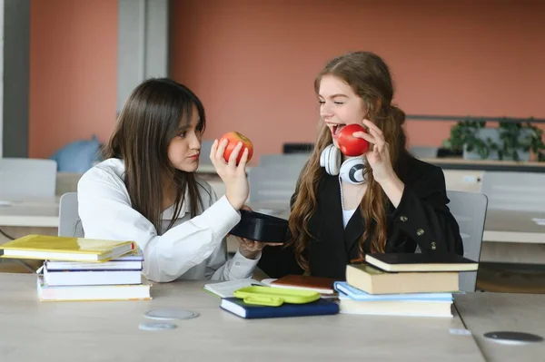 Две Счастливые Улыбающиеся Студентки Сидят Едят Яблоки Учатся Готовятся Экзаменам — стоковое фото