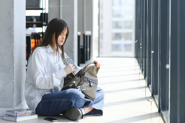 Stock image Teen girl studying with textbook writing essay learning in classroom