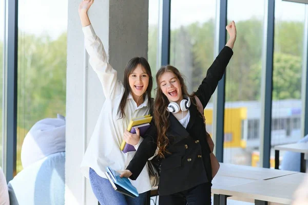 Duas Jovens Mulheres Com Livro Conversando Enquanto Estavam Corredor Faculdade — Fotografia de Stock