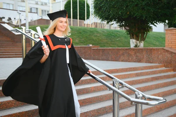 A young female graduate against the background of university