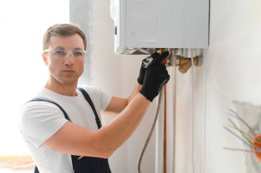 Genç mühendis otonom ısıtmayı ayarlıyor.