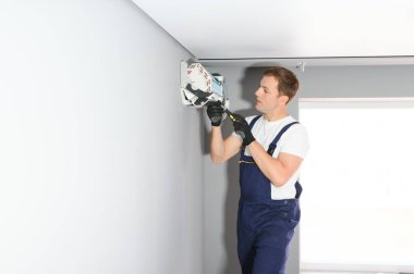 Yakışıklı genç elektrikçi bir müşteri evine klima kuruyor..