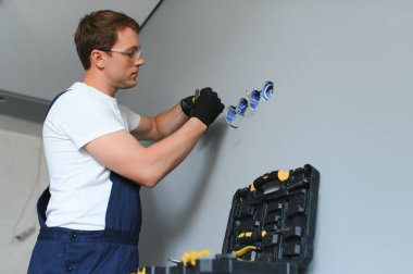 Tornavidayla elektrik prizini tamir eden bir elektrikçi..