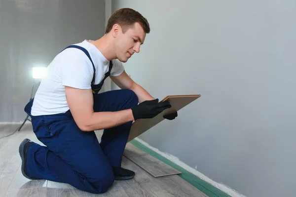 修理工は家で積層床を敷設 — ストック写真