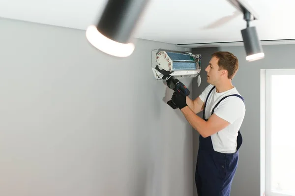 室内のエアコンを固定男性技術者 — ストック写真