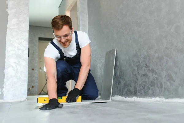 Male Construction Worker Installs Large Ceramic Tile — Stock Photo, Image