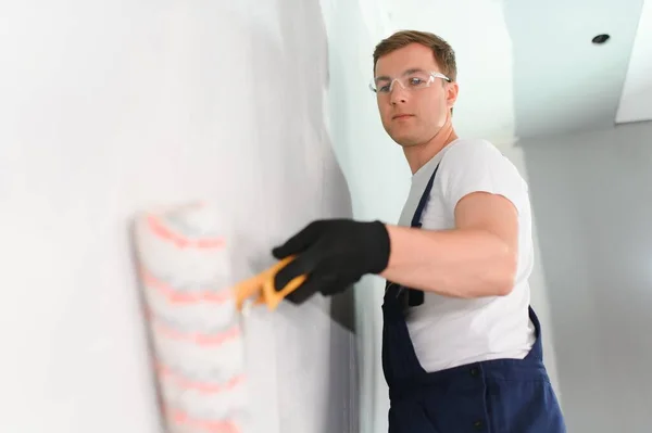 建物の修復しホーム コンセプト 絵画ローラを保持している手袋の男性のクローズ アップ — ストック写真