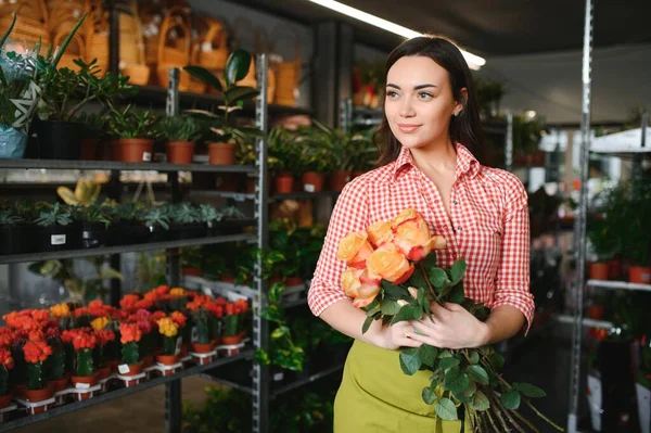 Young beautiful woman florist make bouquet of flowers at flower shop.