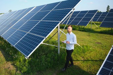 Young architect standing by solar panels.