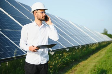 Young architect standing by solar panels.