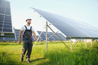 Güneş panelleriyle ayakta duran bir tamirci.