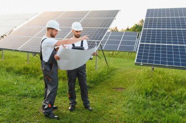 Güneş paneli üzerinde çalışan iki işçi..