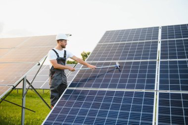 Worker cleaning solar panels after installation outdoors clipart