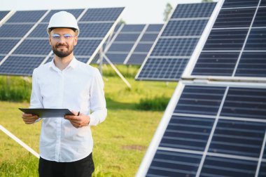 Solar power plant. Man standing near solar panels. Renewable energy