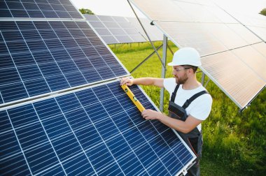 Dışarıda güneş panelleri kuran işçiler