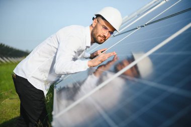 Solar power plant. Man standing near solar panels. Renewable energy