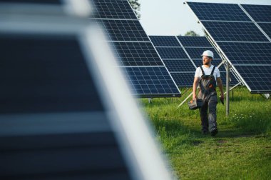 Güneşli bir günde üniformalı ve güneş pilli bir erkek işçi.