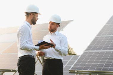 Mühendis ve işadamı yeni ekoloji projesi planlıyorlar. Güneş paneli çatısı etrafında.