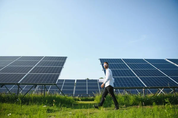 太陽光パネルを背景にした男性労働者太陽光発電所 — ストック写真