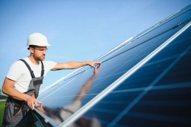 Güneş panelleriyle ayakta duran bir tamirci.