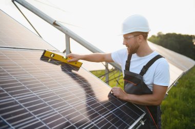 Dışarıda güneş panelleri kuran işçiler.