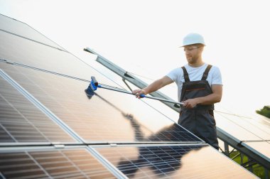 Güneş panellerini temizleyen bir usta toz ve kir oluşturur.