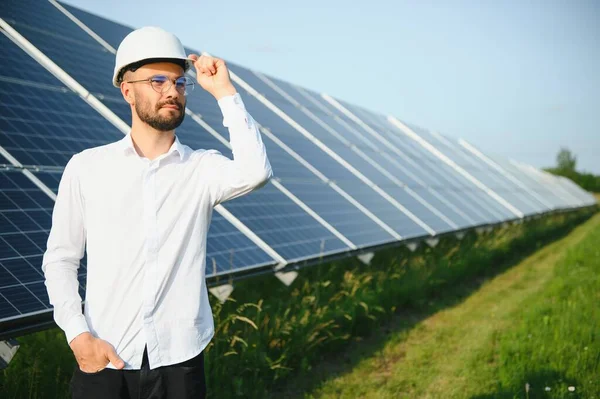 stock image Solar power plant. Man standing near solar panels. Renewable energy