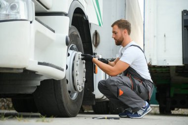 Caucasian Professional Truck Mechanic Rebuilding Heavy Duty Truck Diesel Engine. Automotive Industry Theme