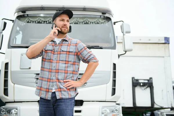 truck driver tending a client on the phone.