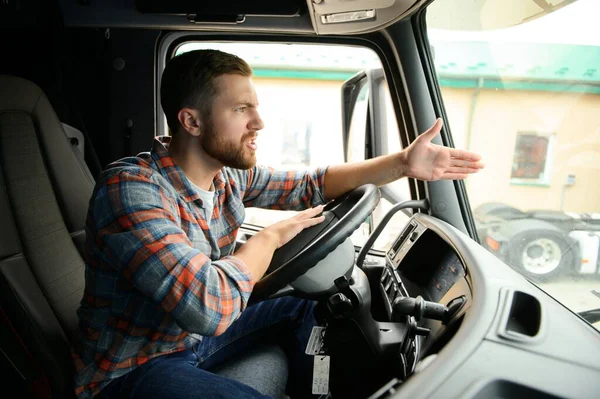 driver behind the wheel in truck cabin.