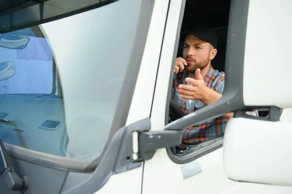 Male truck driver talking by CB radio system in his vehicle.