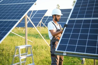 Hintli bir işçi güneş panelleri kuruyor. Yenilenebilir enerji kavramı