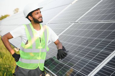 Hintli bir işçi güneş panelleri kuruyor. Yenilenebilir enerji kavramı