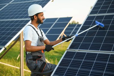 Hintli tamirci güneş panellerini temizleyip toz ve kir oluşturuyor.