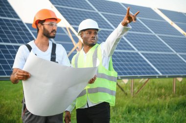 Mühendis ve işadamı yeni ekoloji projesi planlıyorlar. Güneş paneli çatısı etrafında.
