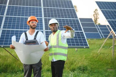 Mühendis ve işadamı yeni ekoloji projesi planlıyorlar. Güneş paneli çatısı etrafında.