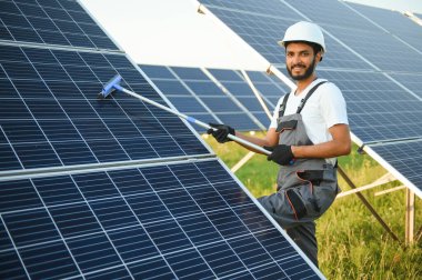 Erkek Arap mühendis güneş panelleri sıraları ile sahada duruyor