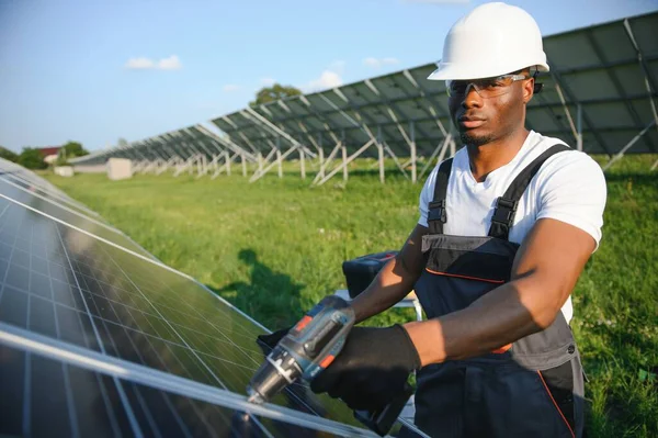 Afrykański Amerykanin Kasku Okularach Dokręca Nakrętki Paneli Słonecznych Śrubokrętem Właściwy — Zdjęcie stockowe