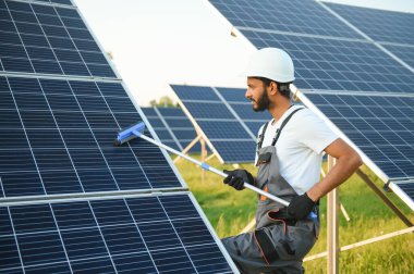 Hintli işçi güneş panellerini temizliyor