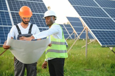 Mühendis ve işadamı yeni ekoloji projesi planlıyorlar. Güneş paneli çatısı etrafında.