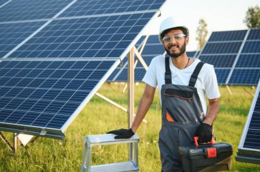 Hintli bir işçi güneş panelleri kuruyor. Yenilenebilir enerji kavramı