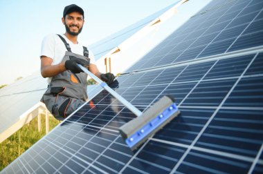 Hintli tamirci güneş panellerini temizleyip toz ve kir oluşturuyor.