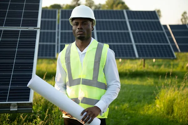 Zbliż Portret Młodego Afrykańskiego Inżyniera Twardym Kapeluszu Trzymającego Plan Słoneczny — Zdjęcie stockowe