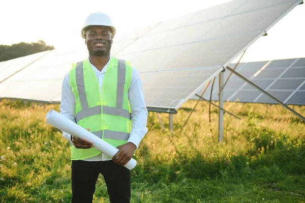 Afrikalı Amerikalı teknisyen güneş panellerinin bakımını kontrol ediyor. Güneş istasyonundaki siyah adam mühendisi.