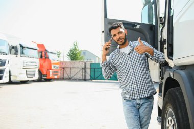 Kamyonetinin yanında duran genç Hintli adam. Nakliye konsepti