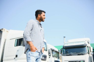 Kamyonetinin yanında duran genç Hintli adam. Nakliye konsepti