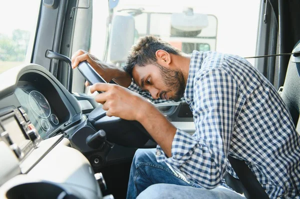 Exhausted truck driver falling asleep on steering wheel. Tiredness and sleeping concept.